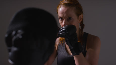 Close-Up-Studio-Shot-Of-Two-Mature-Women-Wearing-Gym-Fitness-Clothing-Exercising-Boxing-And-Sparring-Together